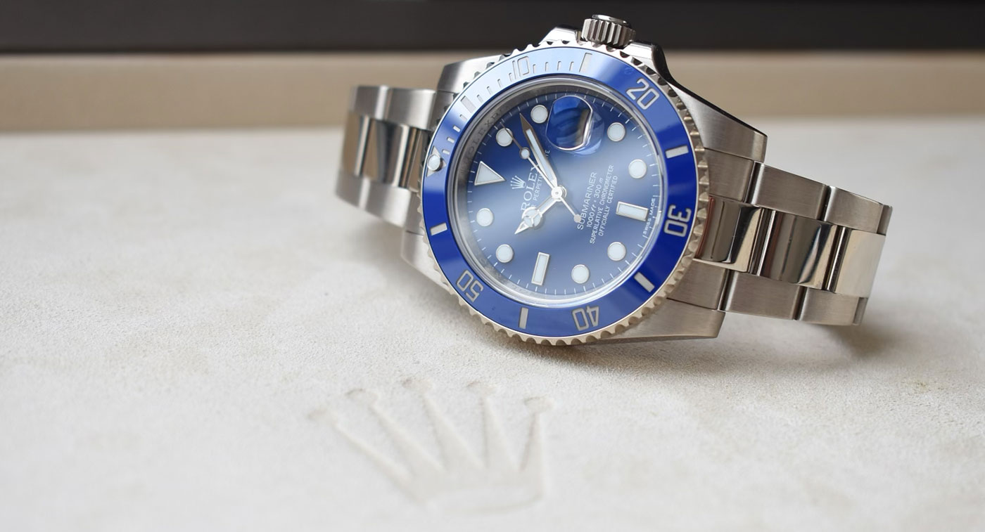 Eine silberne Rolex Uhr mit blauem Zifferblatt und Lünette